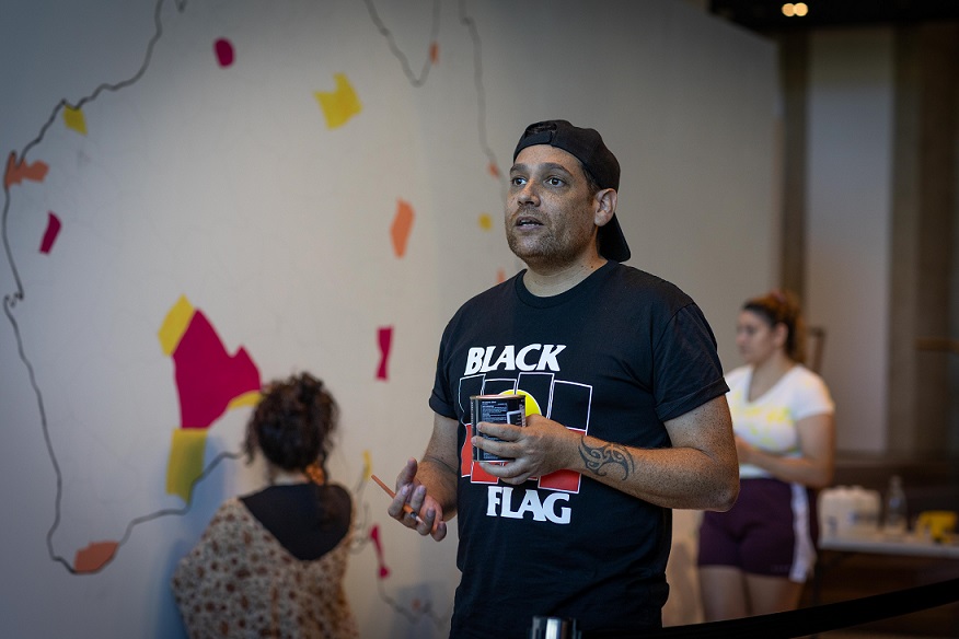 Tony Albert with University students, Terra Nullius (Balancing Act) (in progress), 2021, acrylic paint on plaster wall. Installation view, OCCURRENT AFFAIR, UQ Art Museum, 2021. Reproduced courtesy of the artist and Sullivan + Strumpf, Sydney. Photo: Simon Woods