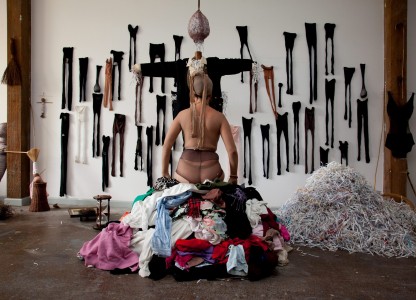 empty stockings: full of love, 2010, nstallation: Mother’s stockings, work uniform, pile of clothes, shredded bills, basket, human hair, wooden egg, mirror, broom, pins, recorded songs, bamboo, timber, fur, hourglass, recorded song from family archive: ‘The Cock is Dead‘